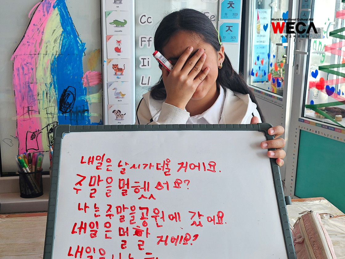 카자흐스탄 아이가 한국어시험을 본 보드를 들고 수줍게 웃는 모습