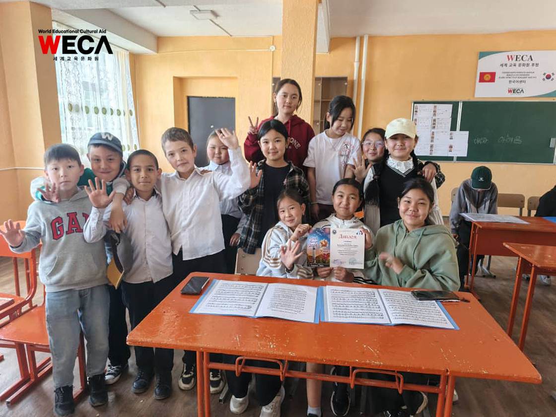 교실에 모여 상장을 함께 들고 환하게 웃고있는 WECA 드림청소년 합창단 아이들