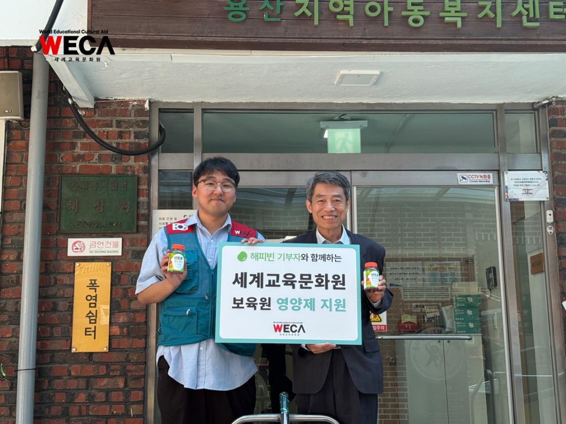 용산 지역아동센터 입구에서 준비한 센트룸 영양제를 들고 기념사진