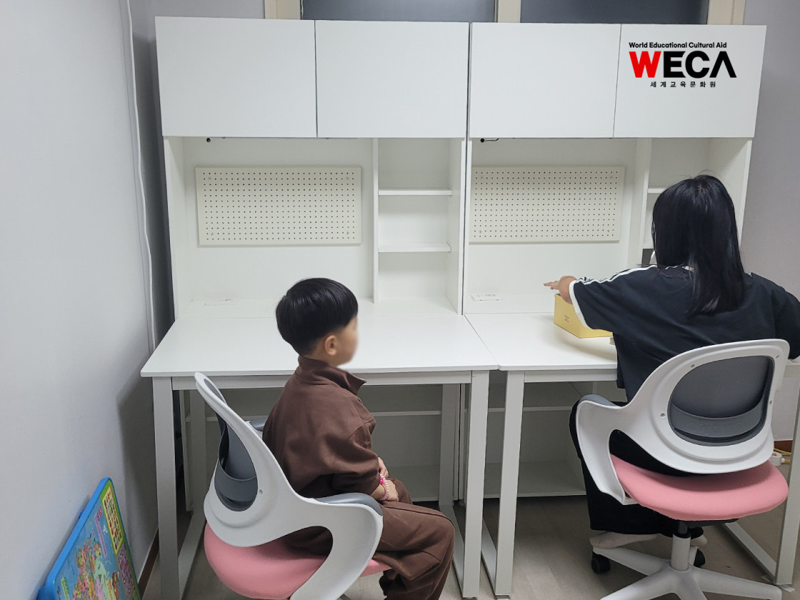 새로 설치된 맞춤형 책상과 밝은 조명 아래서 아이가 앉아있는 사진