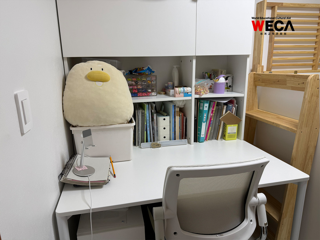 새로 설치된 맞춤형 책상과 밝은 조명 아래서 아이가 앉아있는 사진