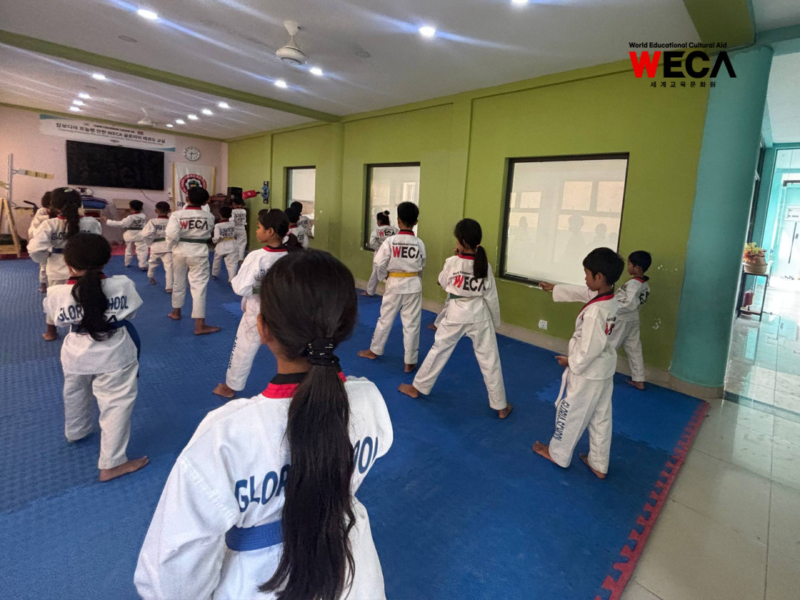 자신의 띠 색깔에 맞춰 그룹별로 발걸음과 손동작을 결합한 품새 훈련에 집중하고 있는 캄보디아 태권도 꿈나무 아동들