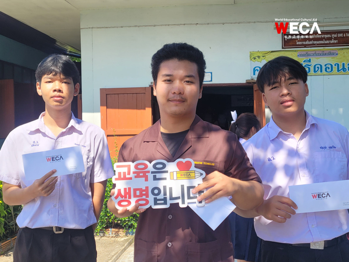 WECA라고 적힌 장학금 봉투를 들고 환하게 웃는 해외결연아동 모습
