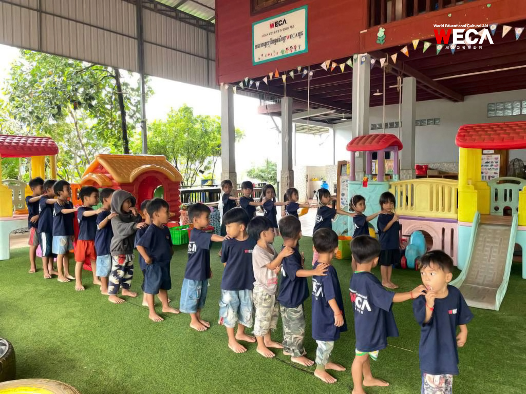 라따나끼리 WECA 코안유치원 교실에서 주변 청소를 하러 나가기 전, 선생님의 안내에 따라 차례대로 바르게 줄을 서서 대기하고 있는 아이들