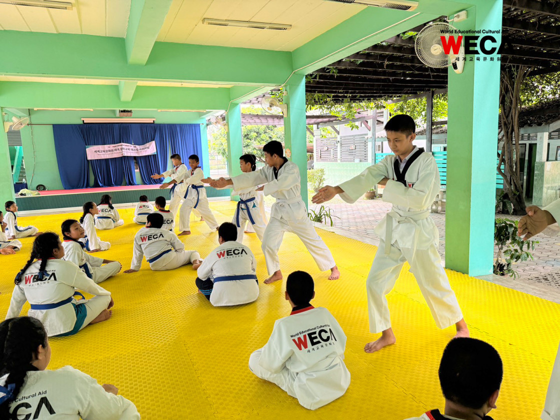 세계교육문화원 WECA 태국 치앙마이 반동초등학교 6학년 학생들이 도복을 입고 태극 4장 품새 동작을 연습하는 모습