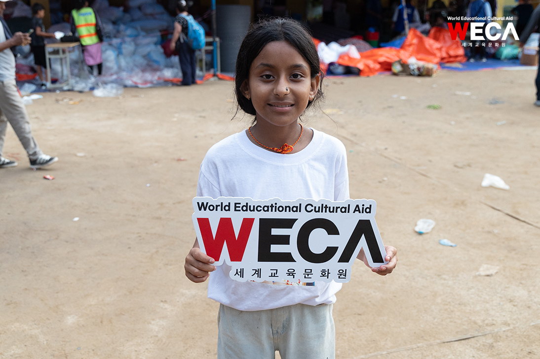 World Educational Cultural Aid WECA Child from Rasuwa region, Nepal holding a panel