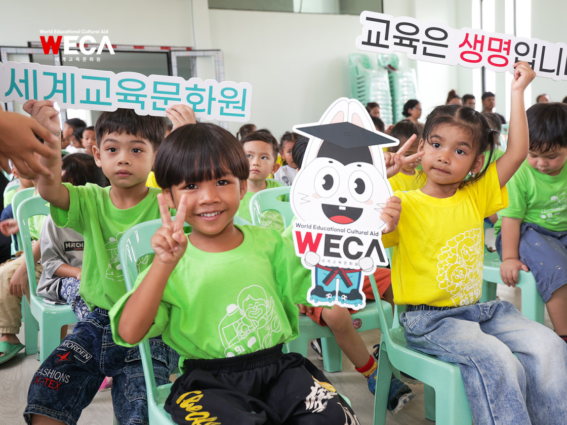 꼬마 헤브론 스쿨 완공식에 모여서 교육은생명이다 세계교육문화원 펫말을 들고 있는 프놈펜 쪽방촌 아이들