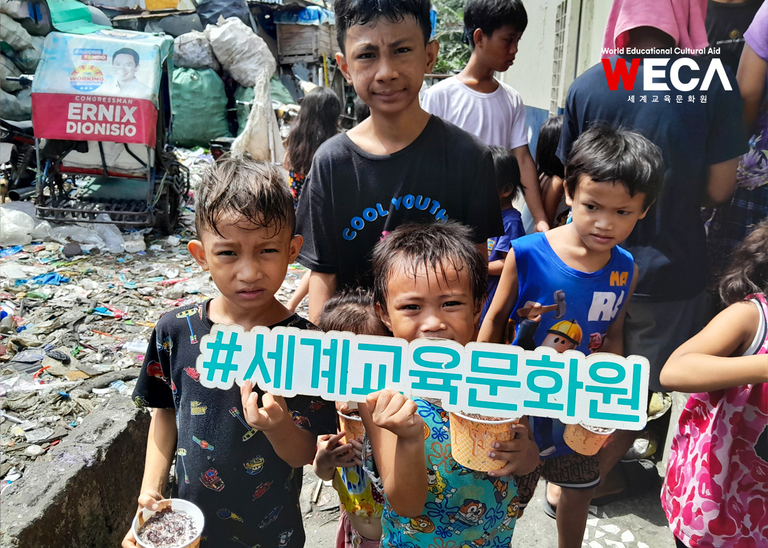 필리핀에서 자주먹는 영양간식인 초콜렛죽을 받아들고 환하게 웃는 WECA어학당 빈민가 아이들