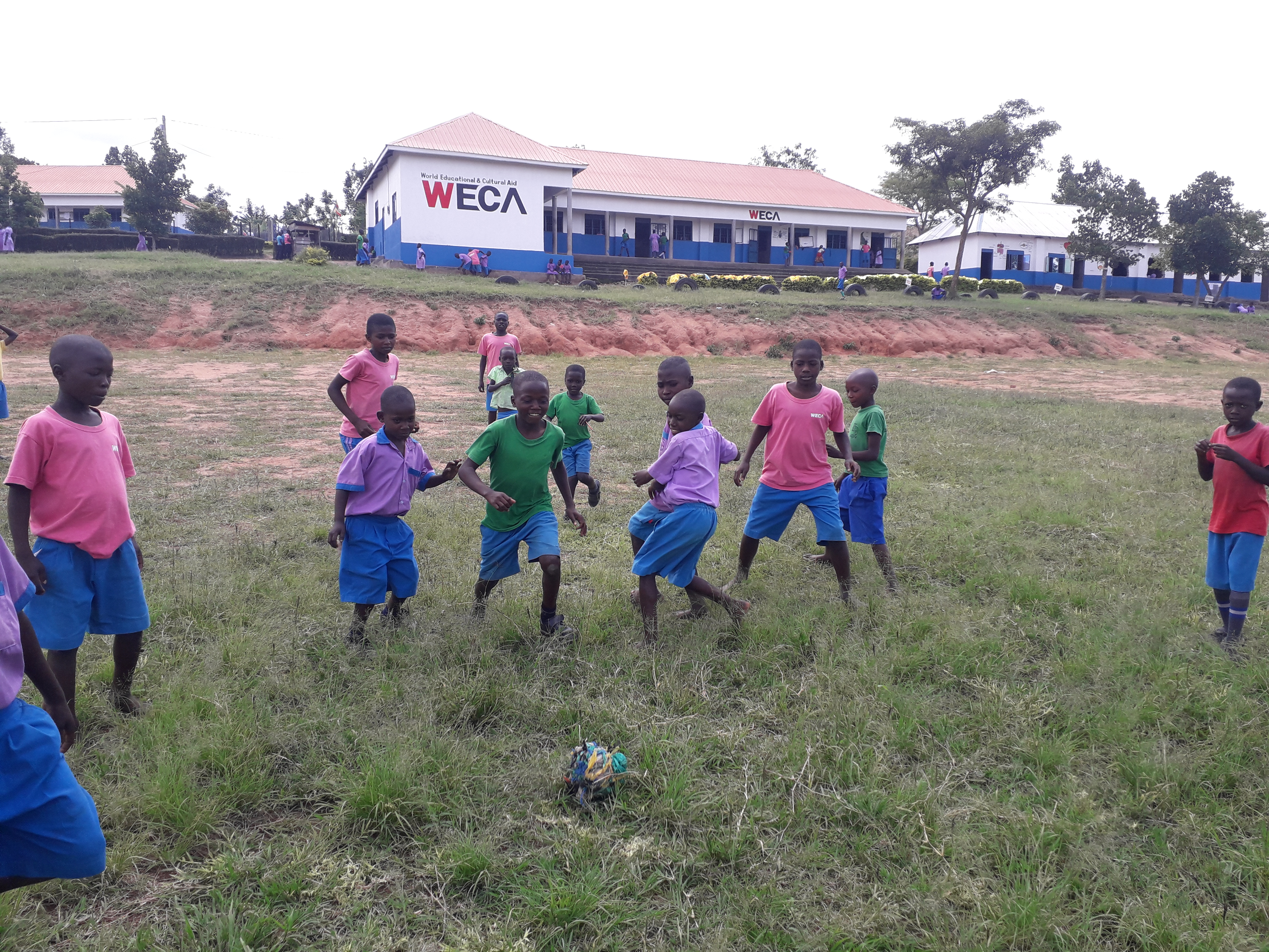 Ugandan children having fun kicking trash soccer balls