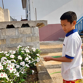Myanmar WECA Taunggyi With Home Child watering flowers