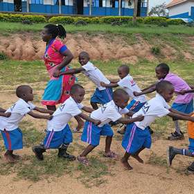 Ugandan school children playing with trains